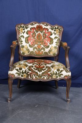 une chaise avec un dossier et des accoudoirs tapissés de fleurs
