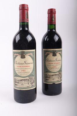 deux bouteilles de vin rouge posées l'une à côté de l'autre sur une surface blanche