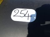 l'ombre d'une personne tenant un téléphone portable devant une plaque d'immatriculation