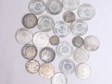 a pile of silver coins on a white surface