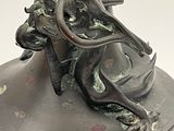 a bronze vase with a dragon head on it