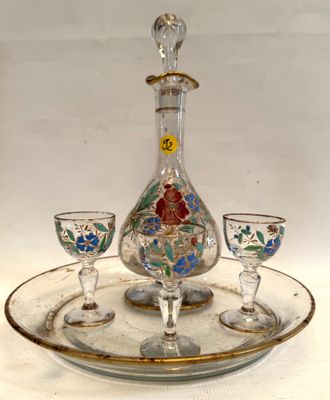 une carafe en verre et deux verres à vin posés sur un plateau