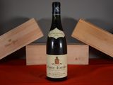 a bottle of wine sitting on a table next to a wooden box
