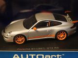 a silver toy car with orange rims in a display case