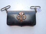 une image représentant un sac à main noir orné d'une fleur de lys