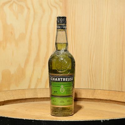 a bottle of chartreusus sitting on top of a barrel