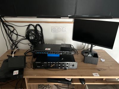 un bureau sur lequel se trouvent un écran, un ordinateur portable et d'autres appareils électroniques