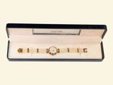 a box with a watch inside of it on a white surface