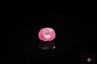 a close up of a pink diamond on a black surface