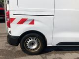 a white van with red and white stripes parked in a parking lot