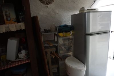 un réfrigérateur blanc et des toilettes dans une petite pièce