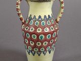 un vase rouge et blanc posé sur une surface grise