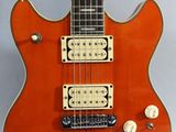an orange electric guitar sitting on top of a white table