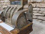 an old fashioned cash register on display in front of a stone wall