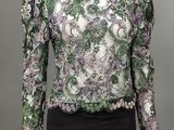 un chemisier vert et violet avec un motif floral sur les épaules