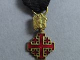an image of a medal with a red cross on a black ribbon