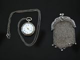 a silver pocket watch and a chain with a chain around it