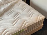 a bed with a mattress and a night stand next to it