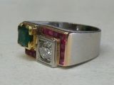 un gros plan d'une bague sertie d'un diamant, d'une émeraude et d'un rubis