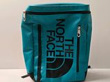 le sac à dos bleu et noir de la marque The North Face posé sur une surface blanche