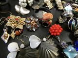 many different types of jewelry on a black table