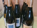 six bouteilles de vin sont posées sur une table devant un carton
