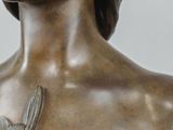 bronze statue of a woman with a flower on her chest