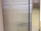 a stainless steel refrigerator in the middle of a room