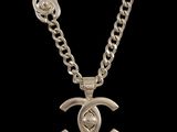 a silver necklace with a chain that has a chanel logo on it