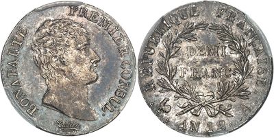 a close up of a silver coin with a crown on it