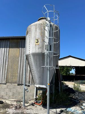 un grand réservoir métallique situé à l'extérieur d'un bâtiment