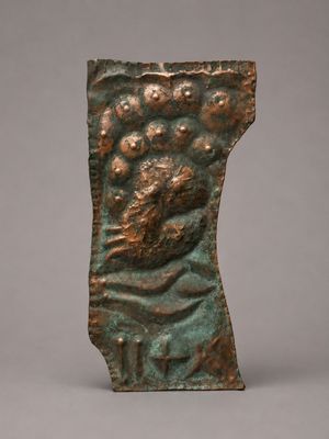 a bronze sculpture of a man ' s head on a rock