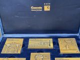 gold plated coins in a case with a blue velvet lining