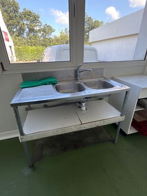 un lavabo dans un coin d'une pièce dotée d'une fenêtre