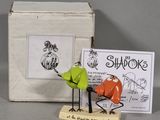two figurines of birds that are standing next to a box