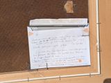 a piece of paper taped to a window with a note attached to it