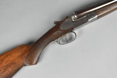 a close up of a rifle with a wooden handle on a table