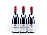 three bottles of red wine sitting next to each other on a white surface