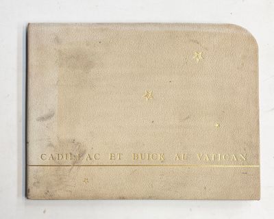 un vieux livre posé sur une table blanche à côté d'un mur blanc