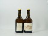 deux bouteilles de vin posées l'une à côté de l'autre sur une surface blanche