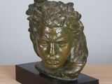sculpture of a head of a man with a bird on his head
