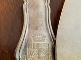 two silver spoons sitting next to each other on a table