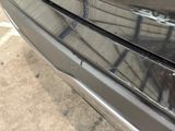 a close up of a car ' s front bumper with a bullet hole in it