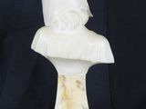 a white marble bust of a man with a hood on his head