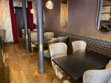 tables and chairs in a restaurant with mirrors on the wall