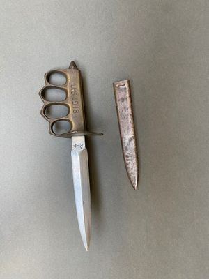 une paire de ciseaux posée à côté d'un couteau sur une table