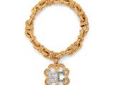 un bracelet en or orné d'un pendentif en forme de trèfle et d'une pierre verte