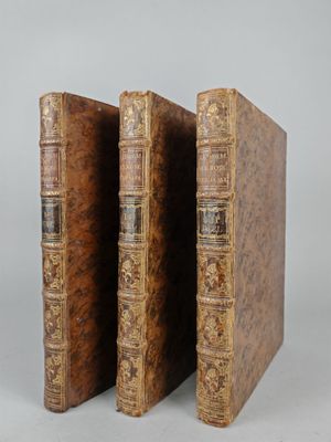 two old books are stacked on top of each other on a table