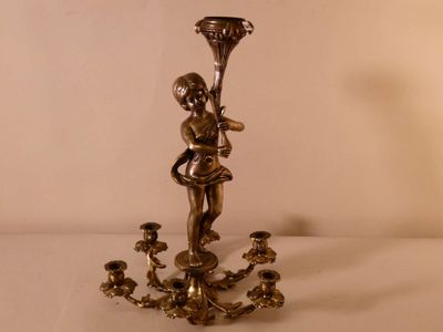 un bougeoir en argent orné d'une petite fille
