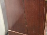 a wooden cabinet that has a clock on top of it
